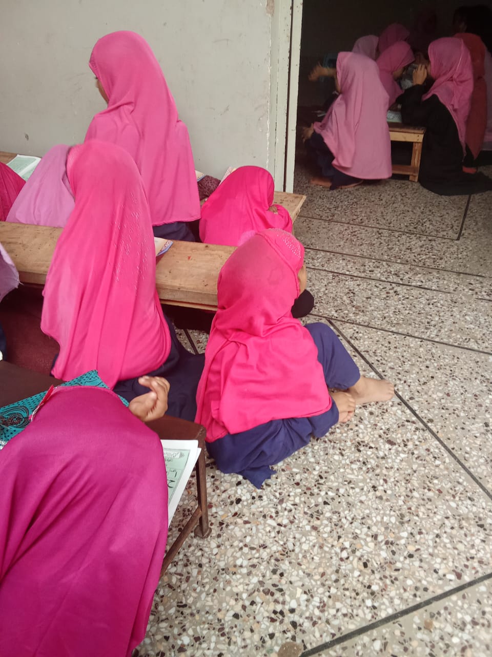 Children seated closely together during a lesson